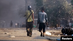 People carry weapons during riots in Meikhtila, Burma, Mar. 22, 2013. 