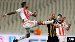 Manuel Da Costa de l'Olympiakos, à gauche, tente d'arrêter le ballon lors de la finale du championnat grec contre l'AEK au Stade olympique d'Athènes, le mardi 17 mai 2016. 