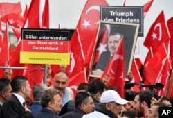 FILE - Turkish protestors hold a banner reading 'Gulen infiltrers the state also in Germany' during a demonstration in Cologne, Germany, July 31, 2016.