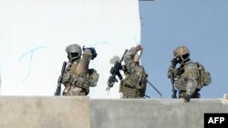 Members of the Tunisian military walk on a balcony during an operation against gunmen in the town of Oued Ellil near the Tunisian capital Tunis, Oct. 24, 2014. 