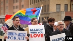 FILE - Spencer Geiger, Carl Johansen and Robert Robert Roman protest for equal marriage outside the Walter E. Hoffman U.S. Courthouse as oral arguments in the case of Bostic v Rainey proceed, Feb. 4, 2014.