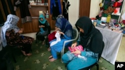 FILE - Victims of violence sew at a shelter operated by the Humanitarian Assistance for the Women and Children of Afghanistan, an NGO, in Kabul, Afghanistan, April 5, 2017. 