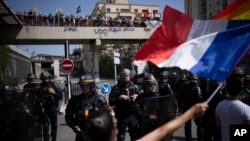 Protesters face French riot police during a demonstration against vaccine passports in Marseille, France, Aug. 14, 2021.