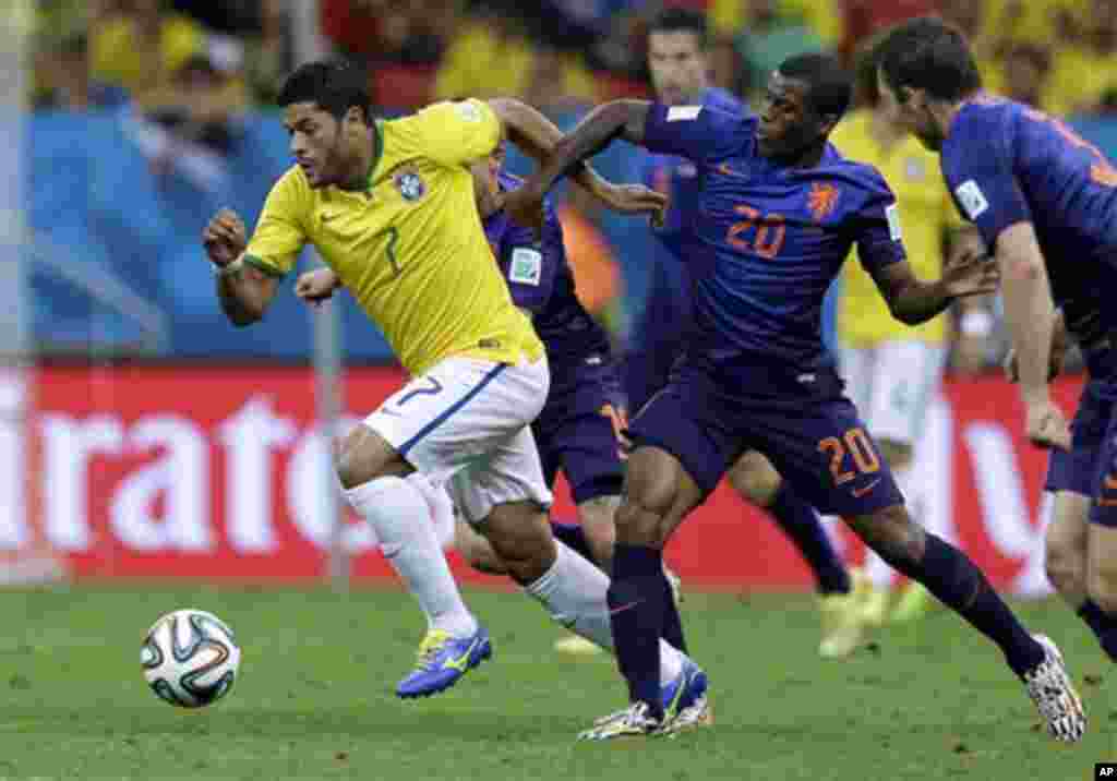 Brazil's Hulk, left, is held by Netherlands' Georginio Wijnaldum during the World Cup third-place soccer match between Brazil and the Netherlands at the Estadio Nacional in Brasilia, Brazil, Saturday, July 12, 2014. (AP Photo/Natacha Pisarenko)