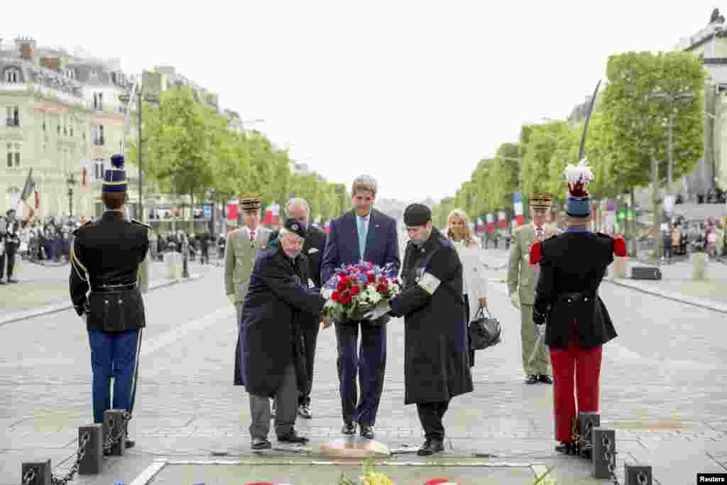 Menteri Luar Negeri John Kerry (tengah) menaruh karangan bunga dalam upacara peringatan kemenangan Sekutu atas Nazi Jerman, di Pemakaman Tentara Tak Dikenal di Paris (8/5). (Reuters/Andrew Harnik)