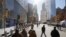 Pedestrians walk along Greenwich Street next to 4 World Trade Center (L) in New York, Nov. 13, 2013.