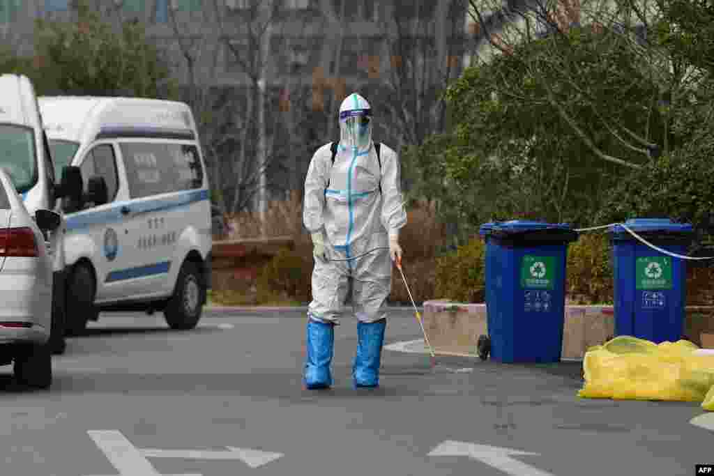 A staff member sprays disinfectant outside a hotel after one person tested positive for the COVID-19 coronavirus, in Nanjing in China&#39;s eastern Jiangsu province.