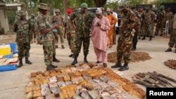 Nigerian military officials stand near ammunition seized from suspected members of Hezbollah after a building raid, Kano, May 30, 2013.