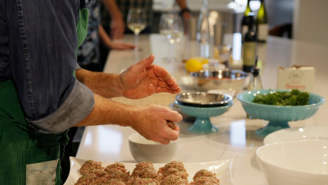 In this photo taken Thursday, April 2, 2020, executive chef Scott Warner, of the Bistro Don Giovanni restaurant, shows how to make Mama Concetta's Meatballs and a salad of fresh greens during a virtual online experience at Bouchaine Vineyards in Napa, Cal