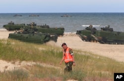 FILE - NATO troops make a massive amphibious landing during NATO sea exercises BALTOPS 2015, June 17, 2015, that are to reassure the Baltic Sea region allies in the face of a resurgent Russia, in Ustka, Poland.