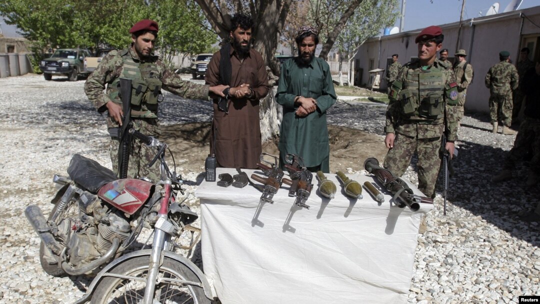 Pemberontak Taliban yang tertangkap dan senjata mereka di propinsi Ghazni (26/4).