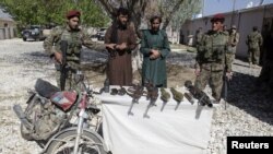 Pemberontak Taliban yang tertangkap dan senjata mereka di propinsi Ghazni (26/4).