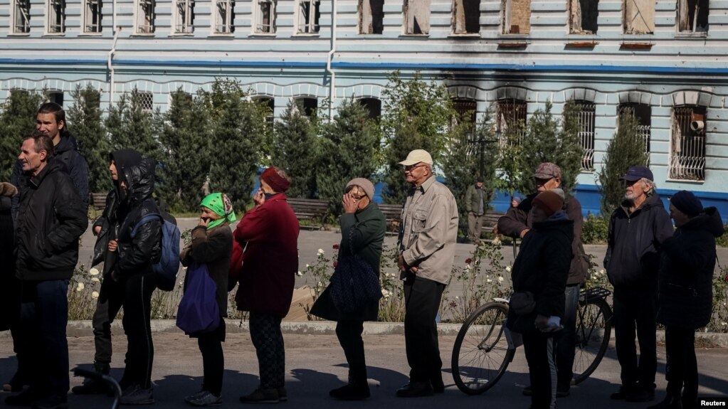 Жителі Ізюма у черзі на отримання гуманітарної допомоги, Харківщина, 25 вересня 2022. REUTERS/Gleb Garanich
