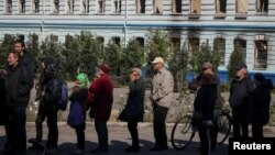 Жителі Ізюма у черзі на отримання гуманітарної допомоги, Харківщина, 25 вересня 2022. REUTERS/Gleb Garanich