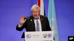 British Prime Minister Boris Johnson waves as he finishes his press conference at the COP26 U.N. Climate Summit, in Glasgow, Scotland, Nov. 10, 2021.