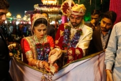 Sepasang pengantin melakukan ritual saat pernikahan massal di Surat, India, Minggu, 24 Desember 2017. (Foto: AP/Ajit Solanki)