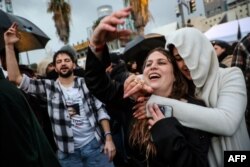 FILE - People in Tel Aviv dance at dawn to electronic music played by Artifex, the last DJ to perform at the open-air Tribe of Nova festival in the Negev desert before it was attacked by Hamas fighters on October 7, 2023.