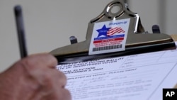 A man fills out voter registration card in Chicago, Oct. 11, 2020.