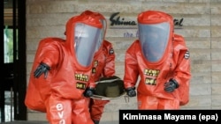 FILE - Tokyo Fire Department special rescue unit members wearing anti-NBC (Nuclear, Biological, and Chemical weapons) suits participate in an anti-terrorism drill in Japan, May 11, 2016.