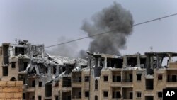 FILE - Smoke rises from a coalition airstrike on an Islamic State position on the front line on the western side of Raqqa, Syria, July 17, 2017.