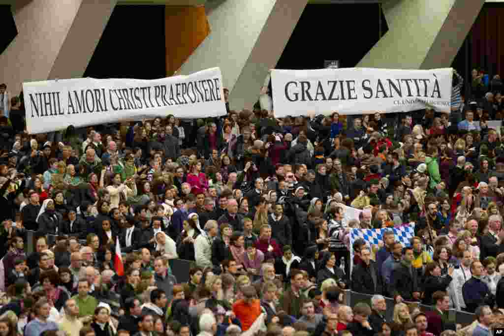 Faithful hold banners reading in Latin "Nihil amori Christi praeponere" (Prefer nothing to the love of Christ), and in Italian "Grazie Santita' " (Thank you Your Holiness) during the pope's weekly general audience at the Vatican Feb. 13, 2013.