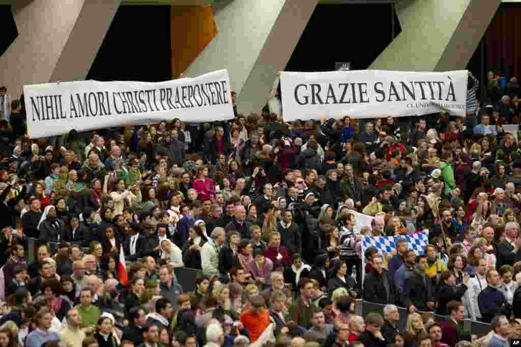 Faithful hold banners reading in Latin &quot;Nihil amori Christi praeponere&quot; (Prefer nothing to the love of Christ), and in Italian &quot;Grazie Santita&#39; &quot; (Thank you Your Holiness) during the pope&#39;s weekly general audience at the Vatican Feb. 13, 2013.