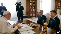 Pope Francis talks to Colombian President Juan Manuel Santos, right, and former President Alvaro Uribe during a meeting at the Vatican, Friday, Dec. 16, 2016.