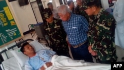 Philippines Defense Secretary Voltaire Gazmin (2nd R) and military chief General Hernando Iriberri (R) visit one of the 53 wounded soldiers at a military hospital in Zamboanga on the southern Philippine island of Mindanao on April 10, 2016, a day after soldiers clashed with the extremist Abu Sayyaf group. 