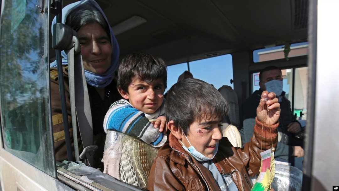 Dua anak laki-laki Yazidi, yang menderita infeksi setelah ditahan oleh kelompok Negara Islam (ISIS) menunggu bersama ibunya dalam bus yang akan pergi ke kota Kurdi, Dohuk di Irak. (Foto: Ilustrasi)