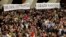 Faithful hold banners reading in Latin 'Nihil amori Christi praeponere' (Prefer nothing to the love of Christ) (L), and in Italian 'Grazie Santita' (Thank you Your Holiness) during Pope Benedict's weekly general audience at the Vatican, Feb. 13, 2013.