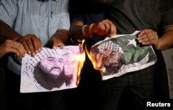 People burn pictures of Masood Azhar, the head of a Pakistan-based militant group Jaish-e-Mohammad, as they celebrate the U.N. Security Council committee's decision to blacklist Azhar, in Ahmedabad, India, May 1, 2019.