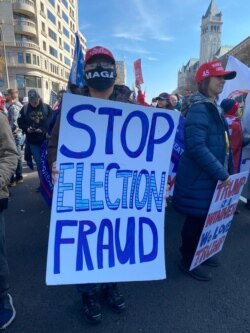Un ciudadano, que porta una cartel con el lema "paren el fraude electoral" se manifiesta el 14 de noviembre de 2020, en Washington DC en protesta por los resultados de los comicios presidenciales.