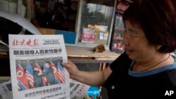 12일 중국 베이징 가판대에 진열된 석간신문 '베이징완바오' 1면에 미북 정상회담 소식이 머리기사로 실렸다.