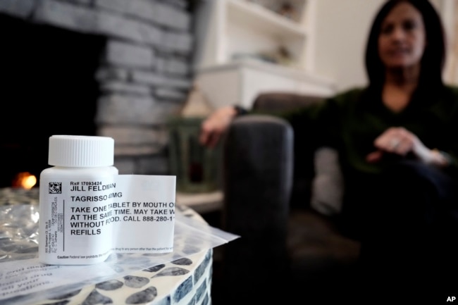 A prescription bottle named osimertinib (brand name: Tagrisso) is seen on a table as Jill Feldman looks at her prescription bottle at her home in Deerfield, Ill., Friday, Jan. 19, 2024. (AP Photo/Nam Y. Huh)