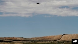 ARCHIVO - Un helicóptero de vigilancia vuela por encima de la frontera entre Estados Unidos y México, el jueves 22 de agosto de 2024, en Sunland Park, Nuevo México.