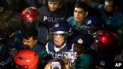 FILE - Police escort former private industry and investment adviser to the former Prime Minister Sheikh Hasina, Salman Fazlur Rahman, center, to the court of the Chief Metropolitan Magistrate in Dhaka, Bangladesh, Aug. 14, 2024.