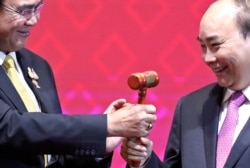 FILE - Vietnam's Prime Minister Nguyen Xuan Phuc takes the gavel from Thai Prime Minister Prayuth Chan-Ocha who hands over the ASEAN chairmanship to Vietnam at the end of the 35th ASEAN Summit, Bangkok, Thailand, Nov. 4, 2019.