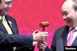 FILE - Vietnam's Prime Minister Nguyen Xuan Phuc takes the gavel from Thai Prime Minister Prayuth Chan-Ocha who hands over the ASEAN chairmanship to Vietnam at the end of the 35th ASEAN Summit, Bangkok, Thailand, Nov. 4, 2019.