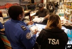 Chef Creole owner Wilkinson Sejour hands out free hot meals to TSA workers at his restaurant at Miami International Airport, Jan. 15, 2019, in Miami.