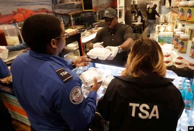 Chef Creole owner Wilkinson Sejour hands out free hot meals to TSA workers at his restaurant at Miami International Airport, Jan. 15, 2019, in Miami.