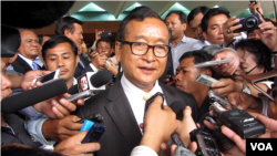 Sam Rainsy, leader of the opposition Cambodia National Rescue Party, is surrounded by journalists after a meeting in Senate headquarters in Phnom Penh, file photo. 