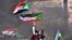 Des manifestants soudanais brandissent des drapeaux nationaux alors qu'ils participent à une manifestation dans la ville de Khartoum Bahri, la ville jumelle nord de la capitale, pour exiger la transition du gouvernement vers un régime civil, le 21 octobre