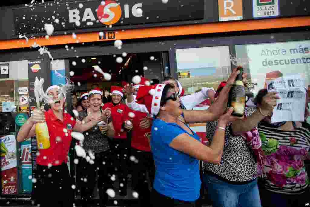 Workers of a gas station celebrate with friends and clients after winning the second prize of the Christmas lottery “El Gordo” (“The Fat One”) in Santa Cruz de Tenerife in the Canary Islands, Spain, Dec. 22, 2013.