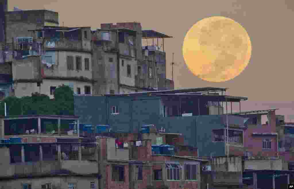 A supermoon sets behind the Mare shanty town complex in Rio de Janeiro, Sunday, May 6, 2012.