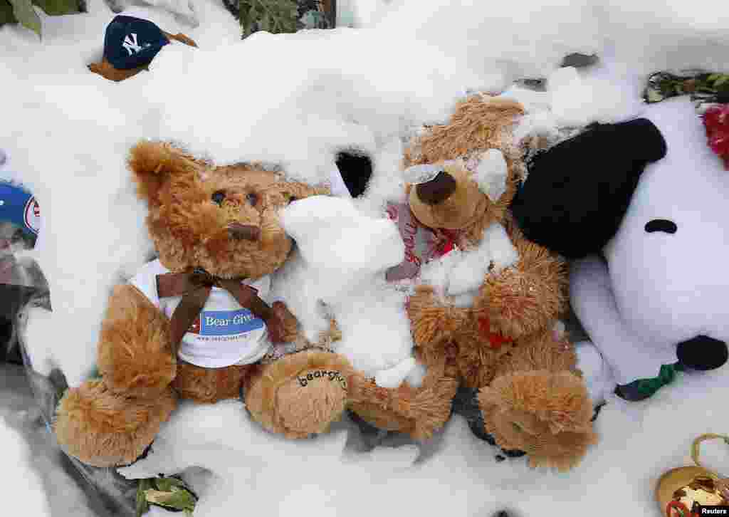 Boneka beruang menghiasi tempat penghormatan untuk para korban penembakan massal di Newtown, Connecticut (2/1). (Reuters/Carlo Allegri)