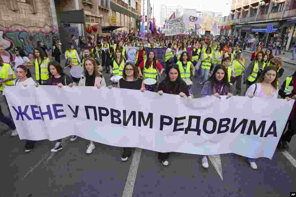 Mujeres sostienen una pancarta que dice: &quot;Mujeres en las primeras filas&quot; durante una marcha en apoyo a las mujeres en el Día Internacional de la Mujer en Belgrado, Serbia, el sábado 8 de marzo de 2025. (Foto AP/Darko Vojinovic)