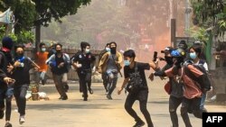 This photo taken by and received from an anonymous source via Facebook March 30, 2021, shows anti-coup protesters running during a demonstration in Yangon's Thaketa township.