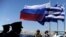 FILE - Greek police and army officers stand by Greek, Russian and EU flags as they wait for the arrival of Russian President Vladimir Putin at Athens' airport, May 27, 2016.
