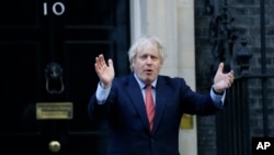 Britain's Prime Minister Boris Johnson applauds on the doorstep of 10 Downing Street in London during the weekly "Clap for our Carers" Thursday, May 28, 2020. The COVID-19 coronavirus pandemic has prompted a public display of appreciation for care…