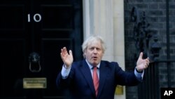 Britain's Prime Minister Boris Johnson applauds on the doorstep of 10 Downing Street in London during the weekly "Clap for our Carers", May 28, 2020. 